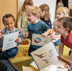 Group of children on carpet with letter flashcards in their hand